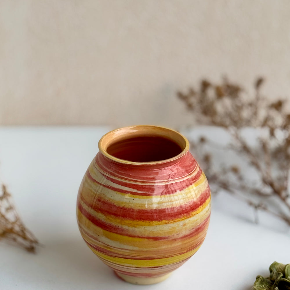 Marigold Swirl Vase, front view showing the red and yellow spiral glaze