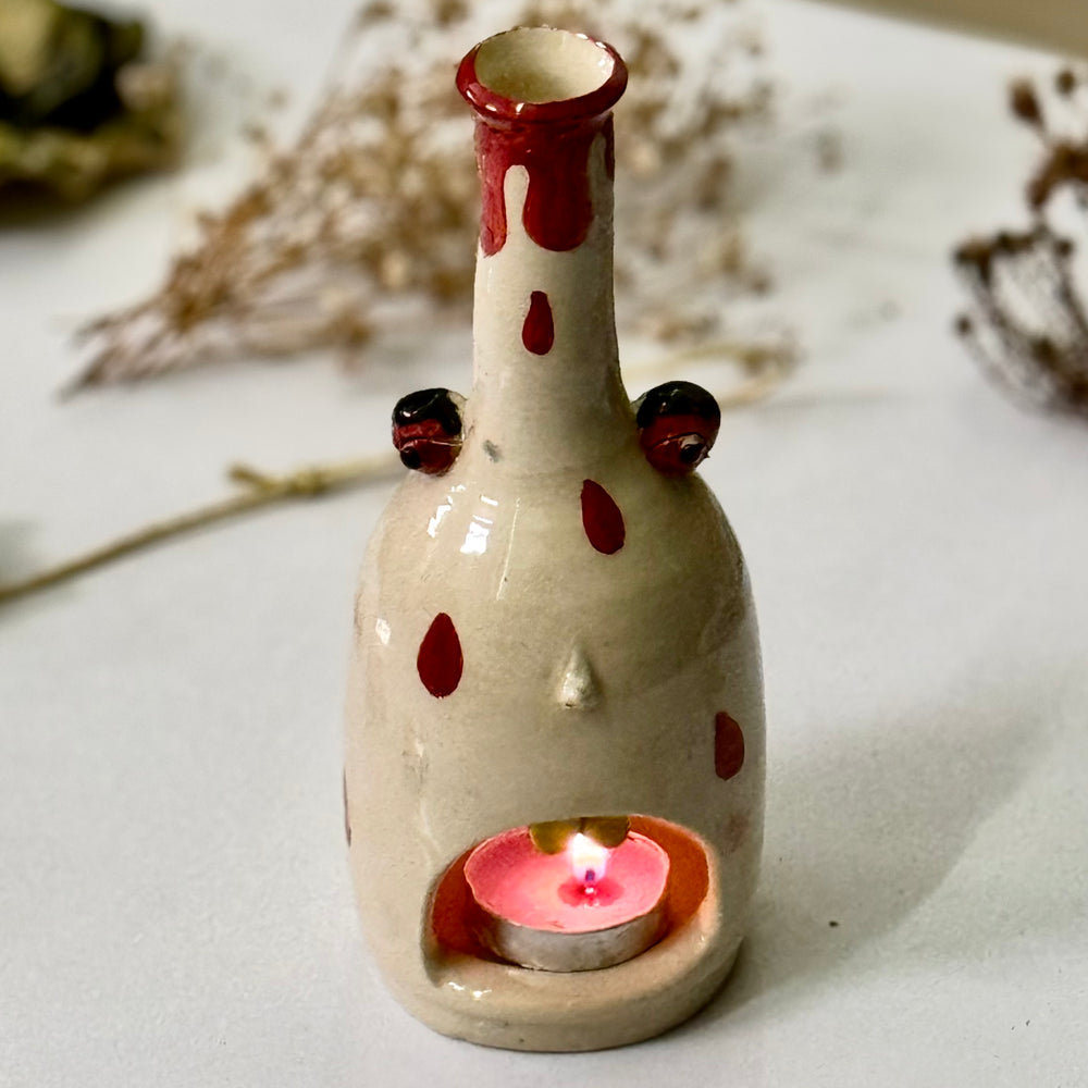 Polka Ghost Tealight, lit, viewed from a slight angle